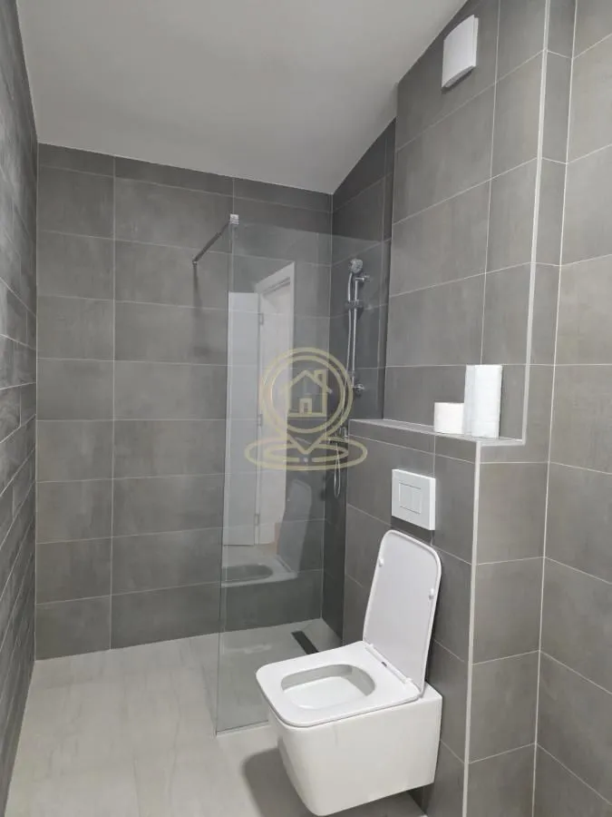 Moderno opremljeno kupatilo sa tuš kabinom i wc šoljom.