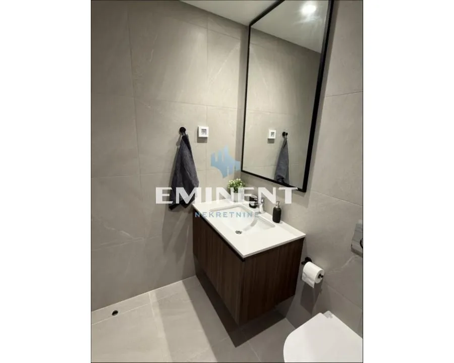 Modern bathroom tiled in gray with a washbasin and a mirror.