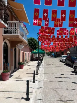 View of the street with buildings and hanging flags. - image 4