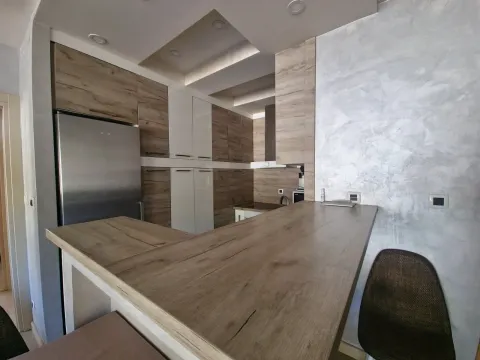Moderna kuhinja sa drvenim elementima i šankom. - image 14