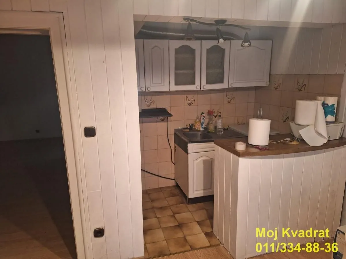 Manja kuhinja sa belim elementima i pločicama.