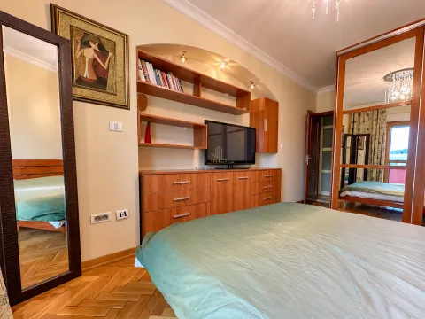 Namještena spavaća soba sa bračnim krevetom, drvenim namještajem i ogledalom. - image 4