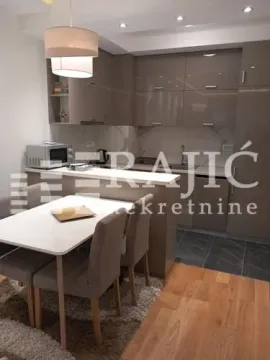 Modern kitchen with a dining area and built-in units. - image 4