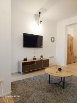 Dnevna soba sa televizorom, komodom i drvenim stočićem. - image 4