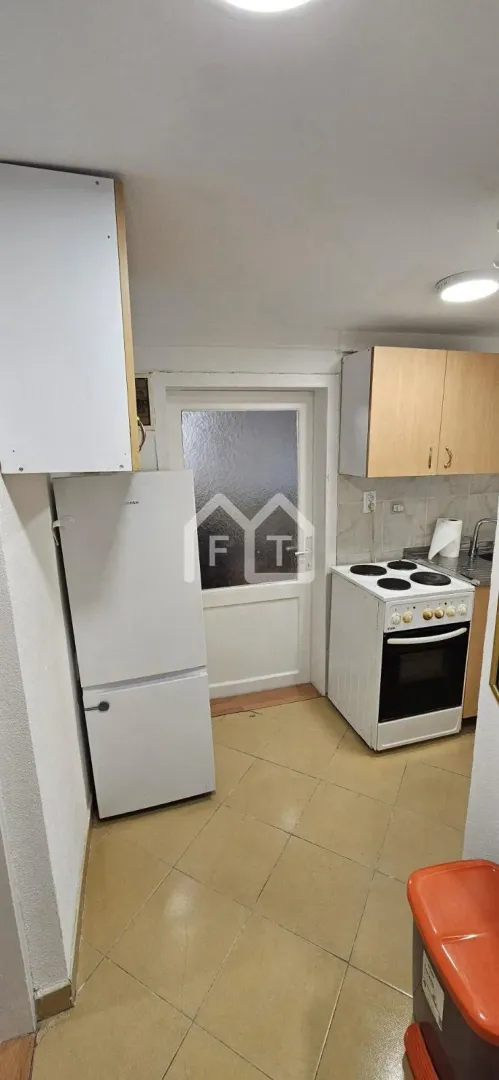 Smaller kitchen with a refrigerator, electric stove, and wall cabinets.