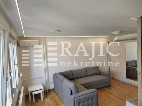 Living room with a sectional sofa, wardrobe, and laminate flooring.
