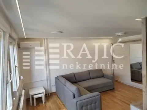 Living room with a sectional sofa, wardrobe, and laminate flooring. - image 5