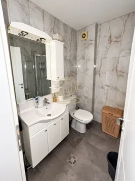 Modern bathroom equipped with a washbasin, toilet, and shower cabin. - image 3