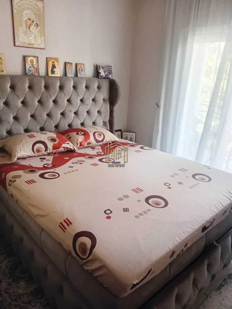 Furnished bedroom with a large double bed and decorative elements on the wall.