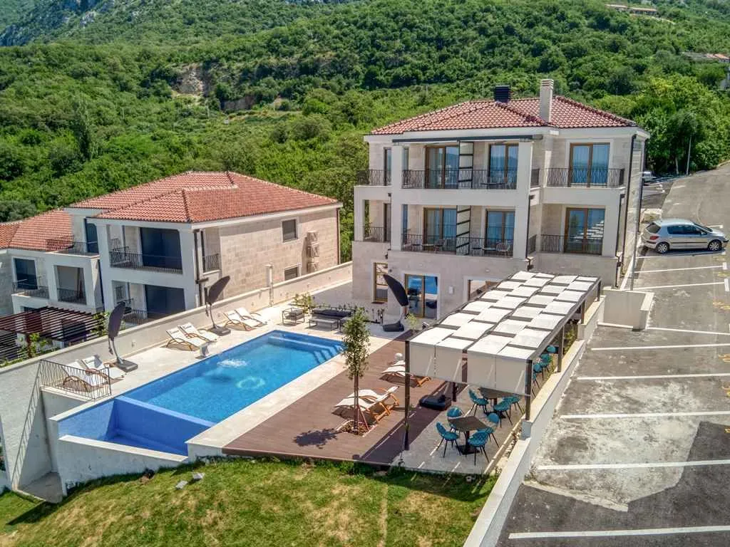 Pogled iz vazduha na modernu vilu sa bazenom i uređenim dvorištem.
