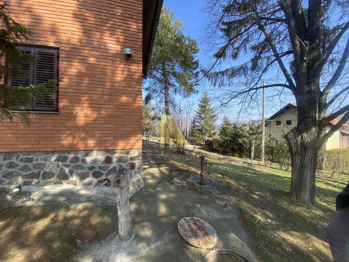 Pogled na dvorište i fasadu kuće sa opekom.