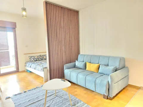 Living room with a sofa and a view of the bedroom separated by a partition screen. - image 8