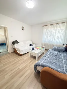 Dnevna soba sa krevetom, trosedom, klub stočićem i prozorom sa zavesama. - image 7