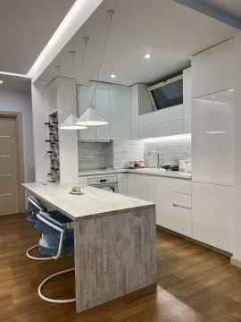 Moderna kuhinja sa bijelim elementima, šankom i ugradnim osvjetljenjem. - image 5