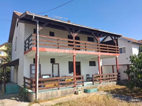 Pogled na spoljašnjost dvospratne kuće sa drvenom terasom i dvorištem. - image 5
