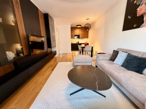 Living room with sofa, coffee table and TV unit, overlooking the dining area and kitchen. - image 4