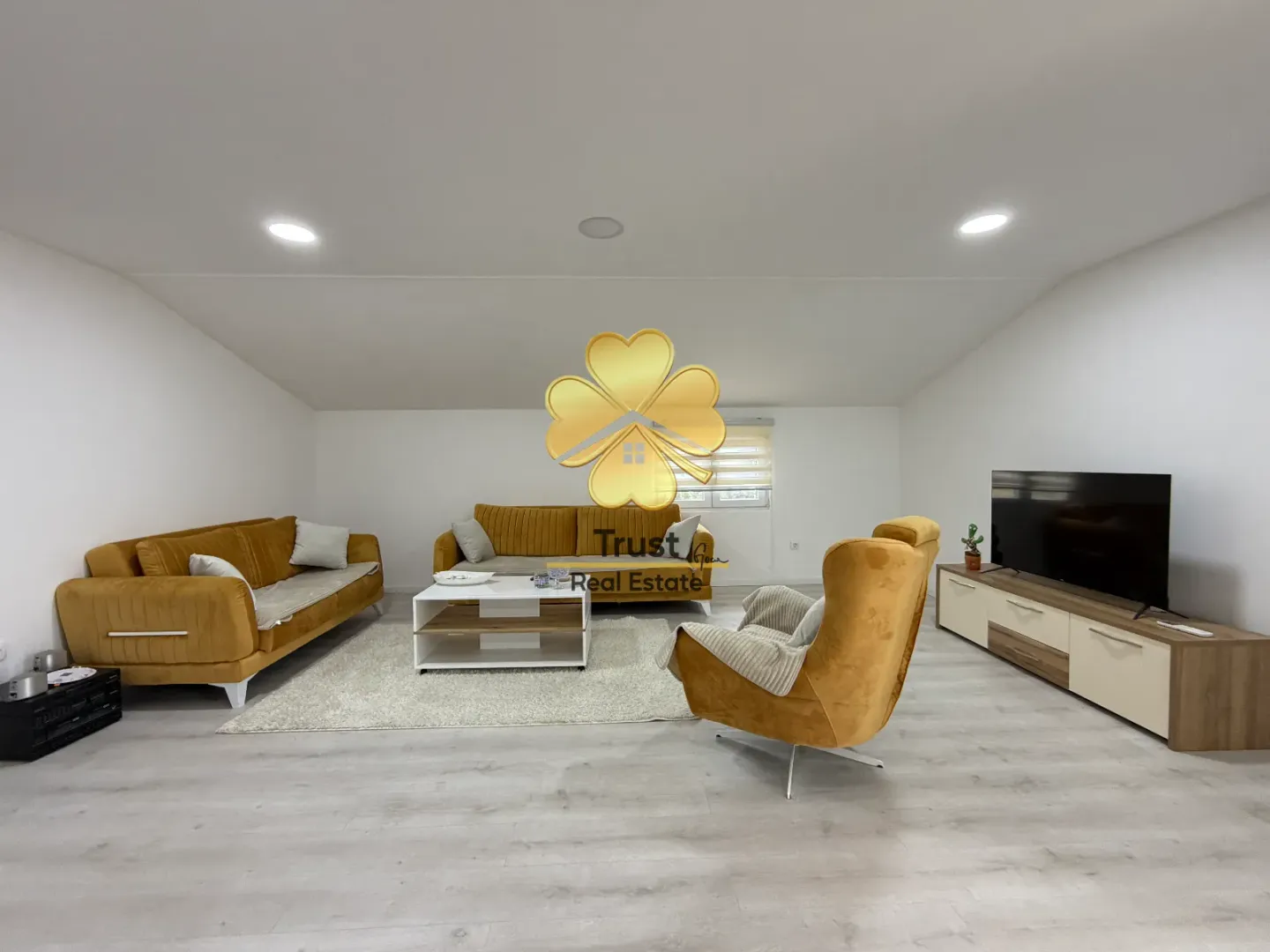 Spacious living room with a sofa set and television.