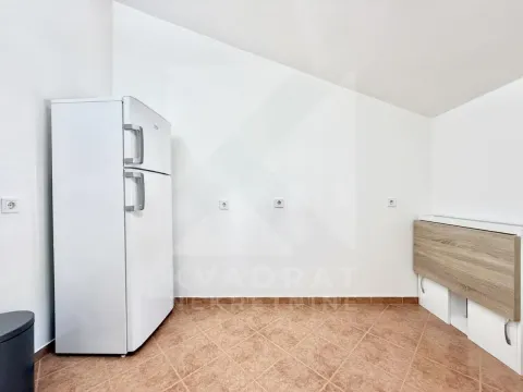 Part of the kitchen with a white refrigerator and ceramic floor tiles. - image 5