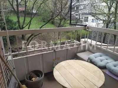 Furnished balcony with a table and a green view. - image 10