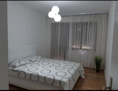 Svijetla spavaća soba sa bračnim krevetom i prozorom prekrivenim zavjesama. - image 5