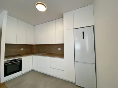 Moderna bijela kuhinja sa drvenom radnom pločom i ugradnim aparatima. - image 3