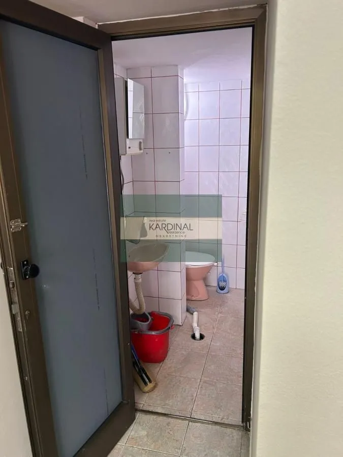 View of a small bathroom with a sink and toilet through the open door.