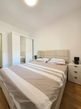 Spavaća soba sa bračnim krevetom, bijelim ormarom i noćnim stočićima. - image 13