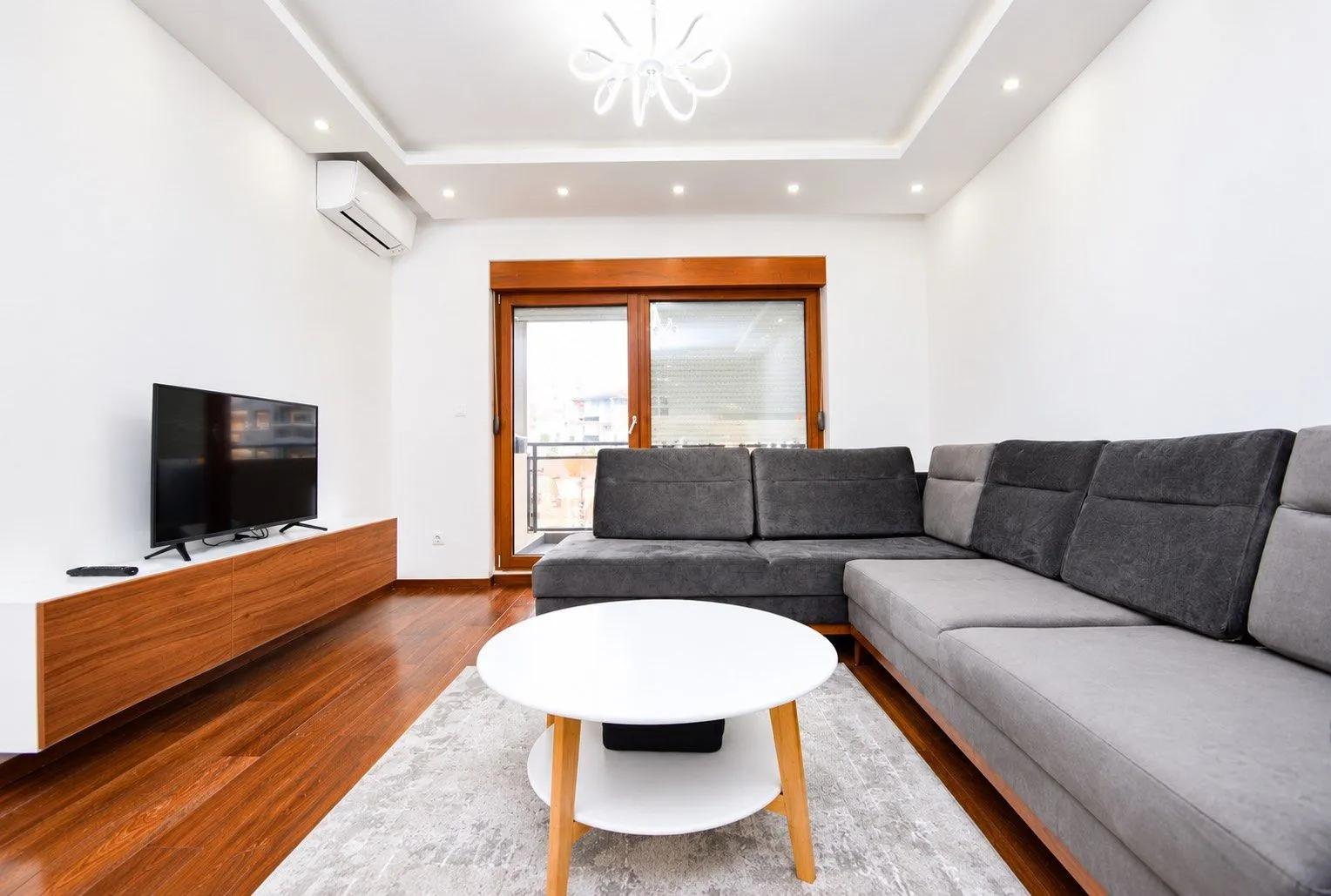Modern living room with a sectional sofa, coffee table, and TV.