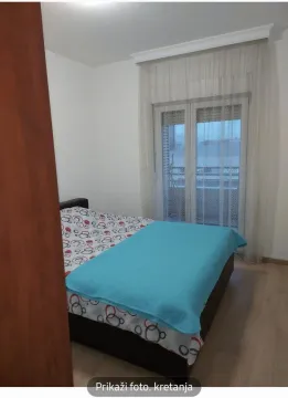 Spavaća soba sa francuskim krevetom i izlazom na balkon. - image 2