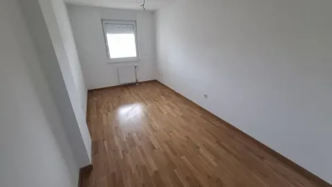 Prazna neopremljena prostorija sa parketom i prozorom. - image 6