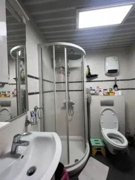 Manje opremljeno kupatilo sa tuš kabinom i toaletom. - image 7