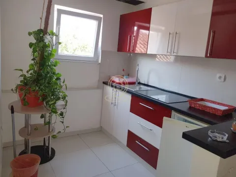 Kuhinja sa crvenim i belim elementima i prozorom. - image 8
