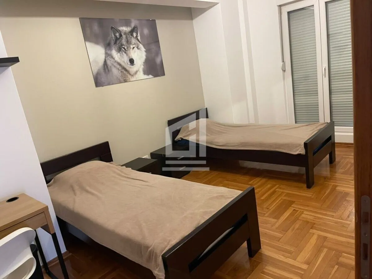 Bedroom with two single beds and parquet flooring.