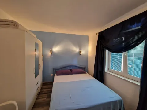 Spavaća soba sa bračnim krevetom, bijelim garderoberom i prozorom sa tamnim zavjesama. - image 6