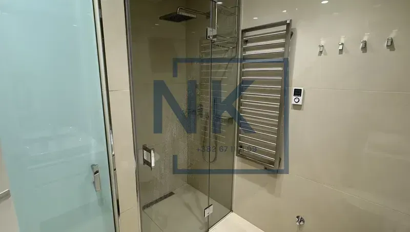 Modern bathroom with a walk-in shower and a towel warmer.