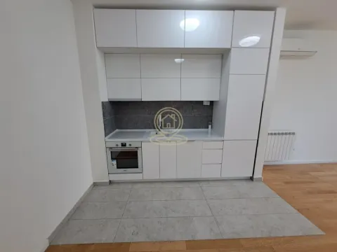 Manja bela kuhinja sa ugradnim aparatima i sivim pločicama na podu. - image 3