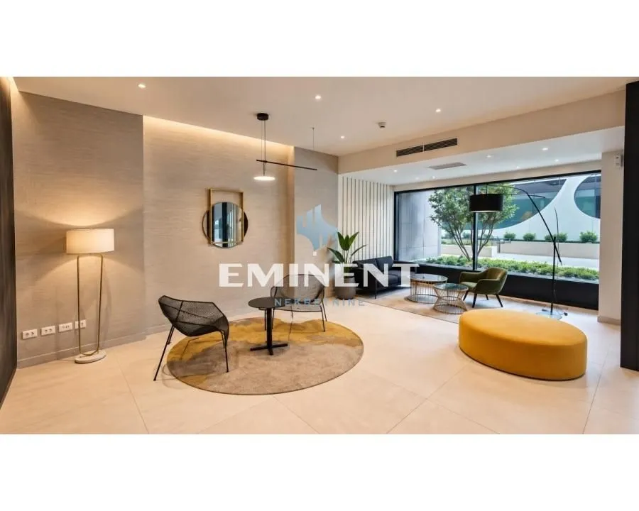 Spacious bright living room with modern furniture and large windows.