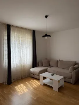 Dnevna soba sa ugaonom garniturom, stočićem i prozorom sa zavjesama. - image 7