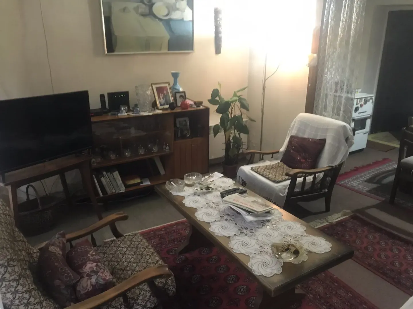 Dnevna soba sa klasičnim namještajem, klub stolom i televizorom.