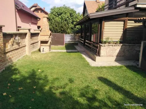 Uređeno dvorište sa travnjakom i zidanim roštiljem pored kuće. - image 4