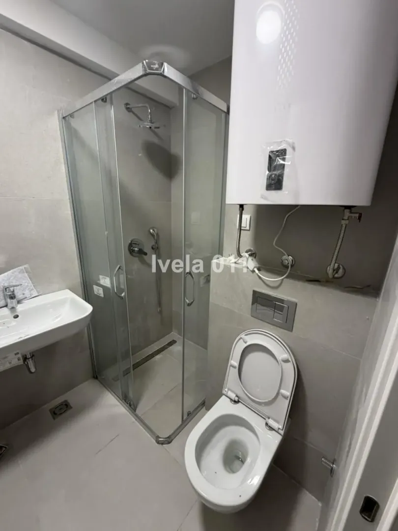 Manje kupatilo sa tuš kabinom, umivaonikom i wc šoljom.