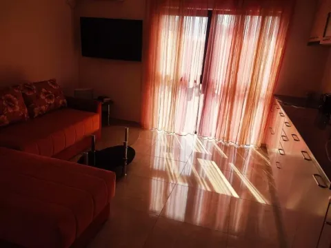 Dnevna soba sa garniturom, televizorom i izlazom na terasu. - image 6