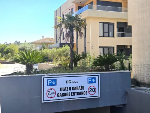 Eksterijer stambene zgrade sa ulazom u garažu i uređenim dvorištem. - image 14