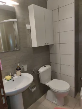 A modern bathroom with white fixtures and grey tiles. - image 19