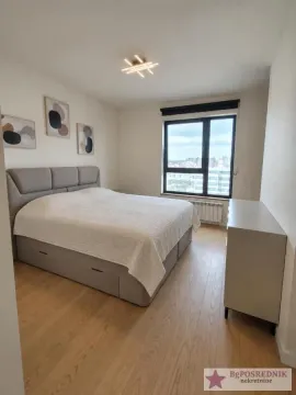Nameštena spavaća soba sa velikim bračnim krevetom i prozorom. - image 4
