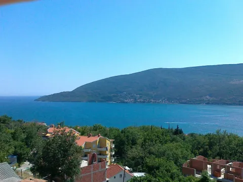Panoramski pogled na more i planine sa okolnim kućama. - image 8