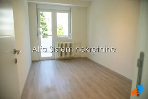 Empty room with laminate flooring and balcony doors. - image 5