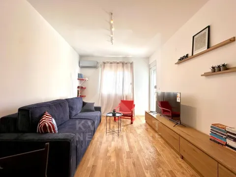 Dnevna soba sa garniturom, televizorom i drvenim podom. - image 3