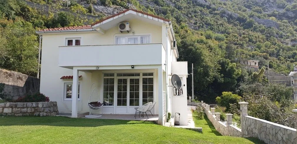 A two-story family house with a neat green lawn.