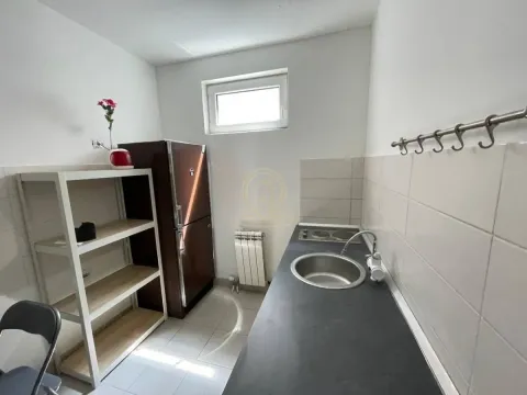 Smaller kitchen with refrigerator, sink and shelves. - image 6